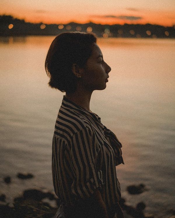 Silhouette of a person in a mindful pose against a serene backdrop.